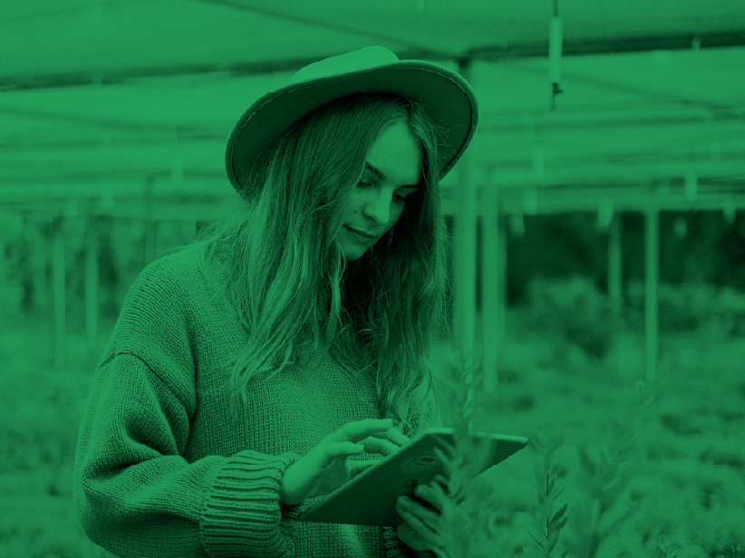 Woman using tablet in greenhouse.