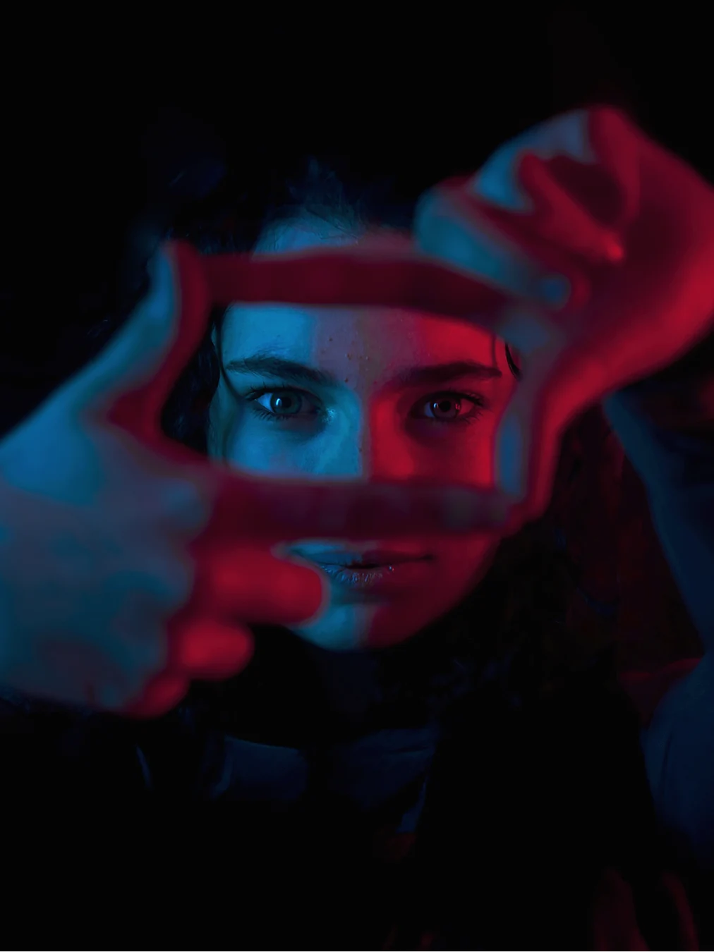Person with cyberpunk aesthetic featuring blue and red lighting effects against a dark background